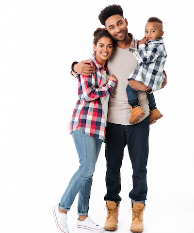 Full length portrait of a happy young african family with their little son standing together isolated over white background